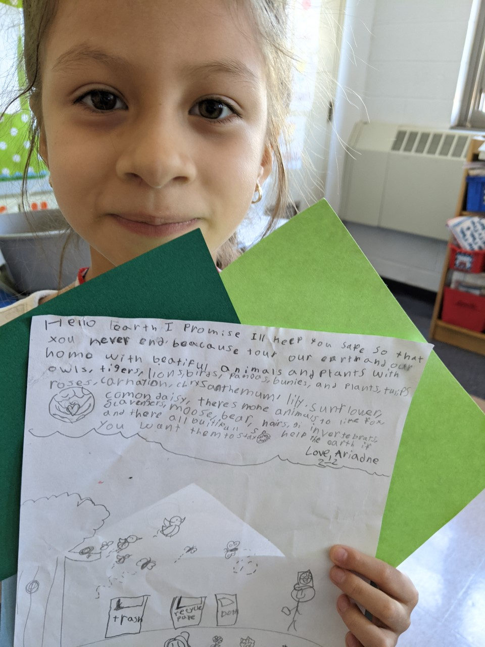 Student holding her Earth Day promise letter