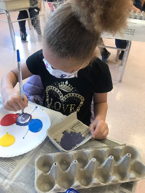 Student painting a recycled egg carton