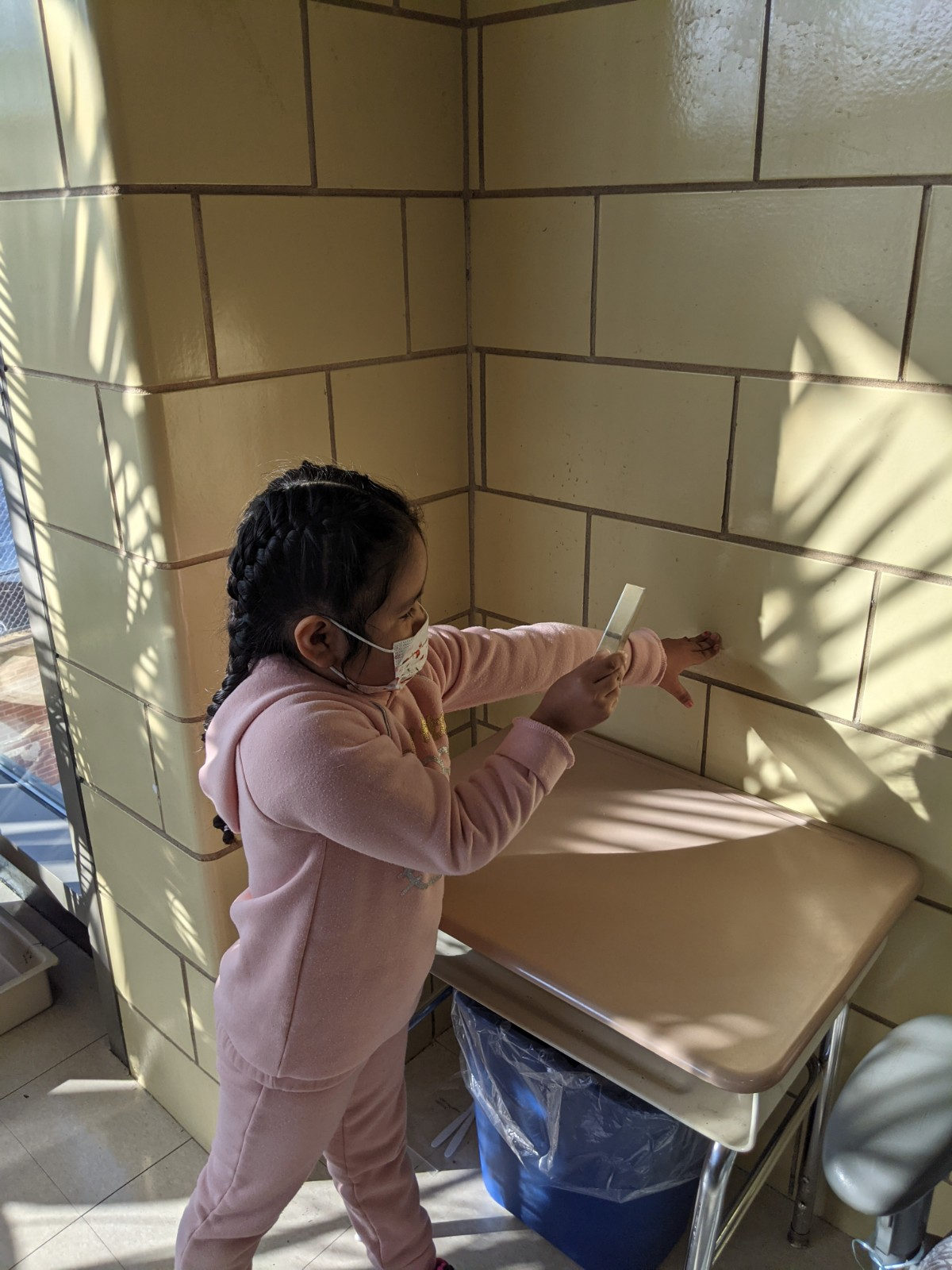 Student pointing to a rainbow of light on the wall