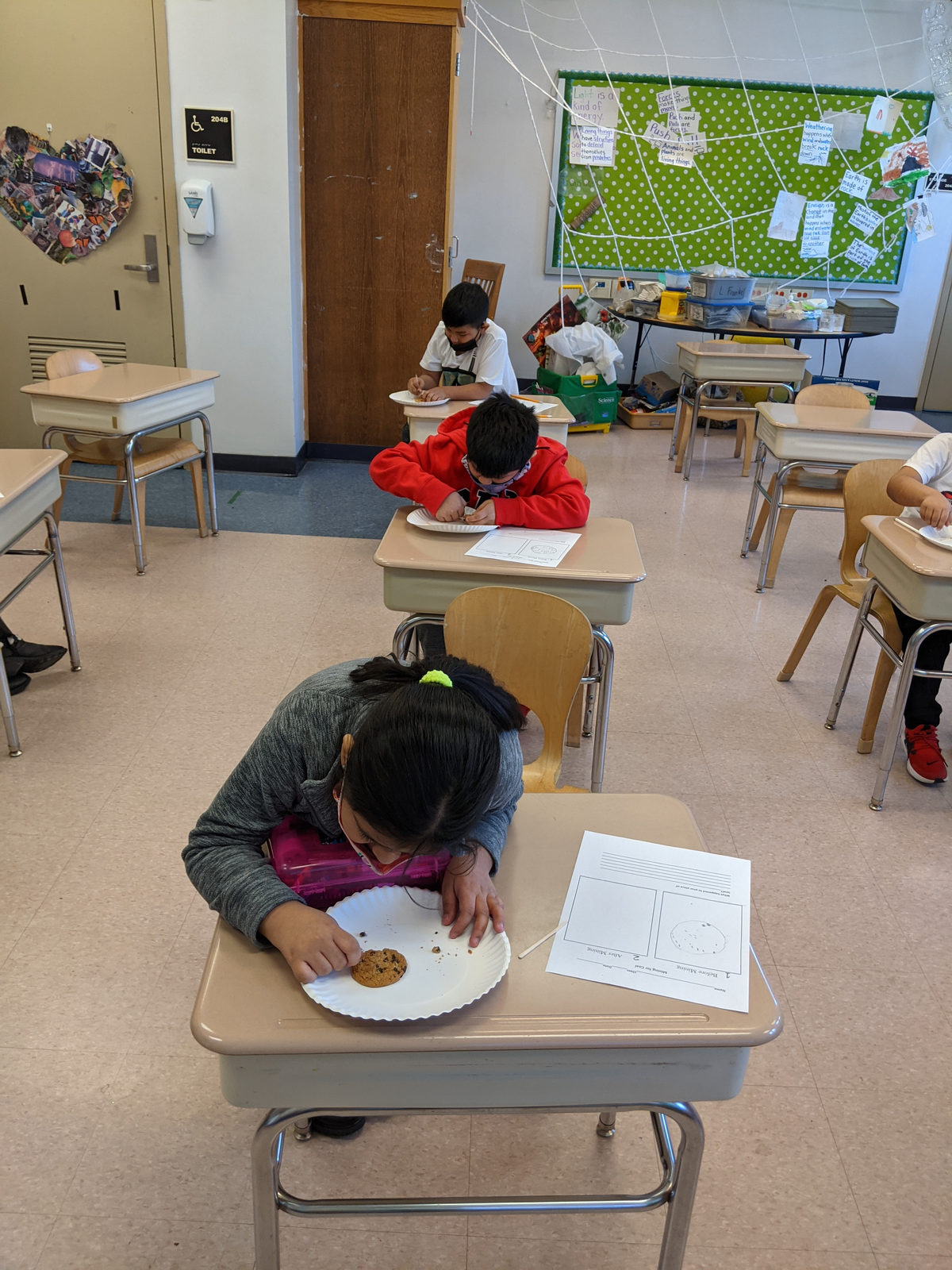 Students mining cookies at their desks to learn about natural resources