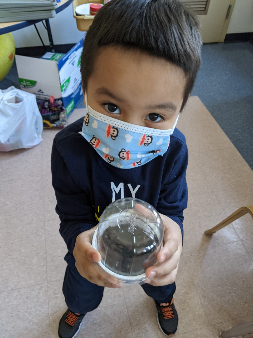 Student holding a mini terrarium made from a recycled cup