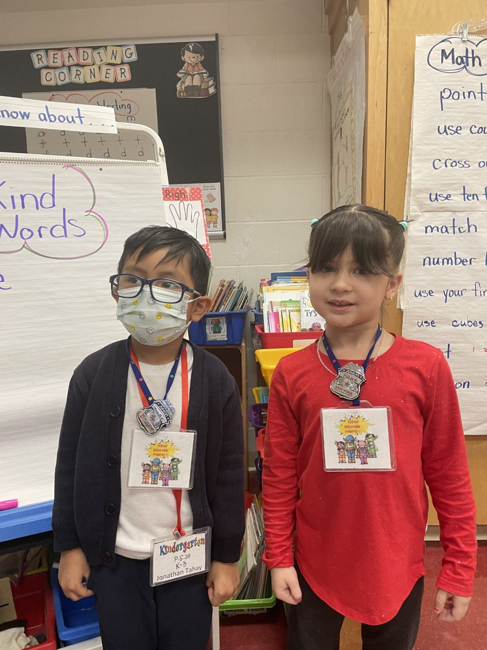 Two students wearing their Kind Words Hero badges