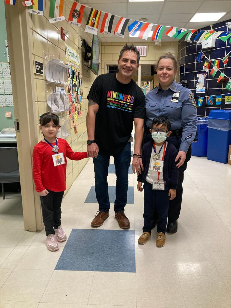 Two Kind Words Heroes in the hallway with Principal Quintana and a police officer