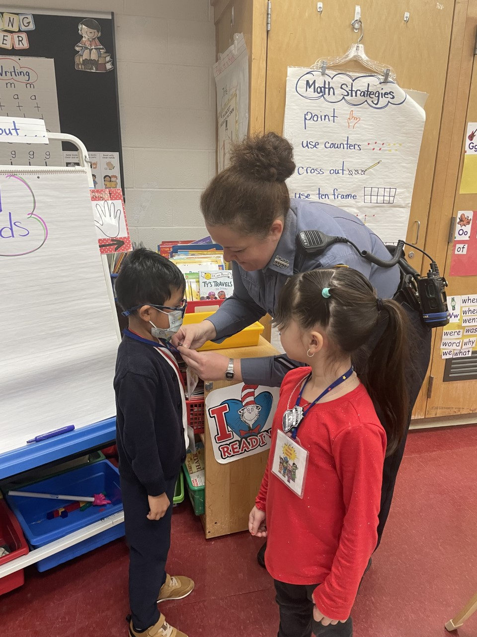 A police officer giving a student a Kind Words Hero badge