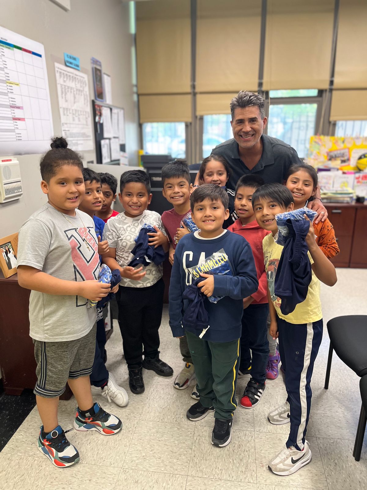 Players posing with their coach in a classroom