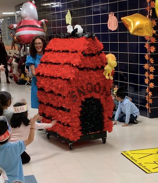 Snoopy's red doghouse float rolling down the hallway in the Thanksgiving Day Parade